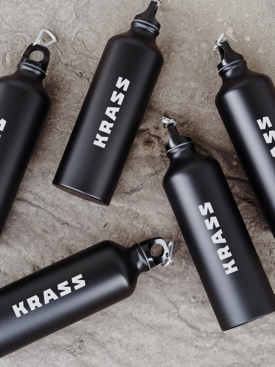 Butelki z logotypem marki leżące na podłodze.