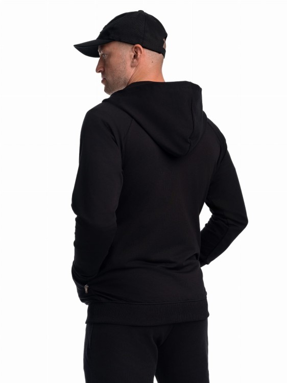 Mężczyzna w czapce i w bluzie z kapturem tyłem.jpg